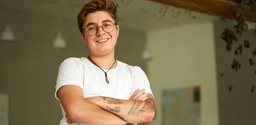 A person smiling with folded arms