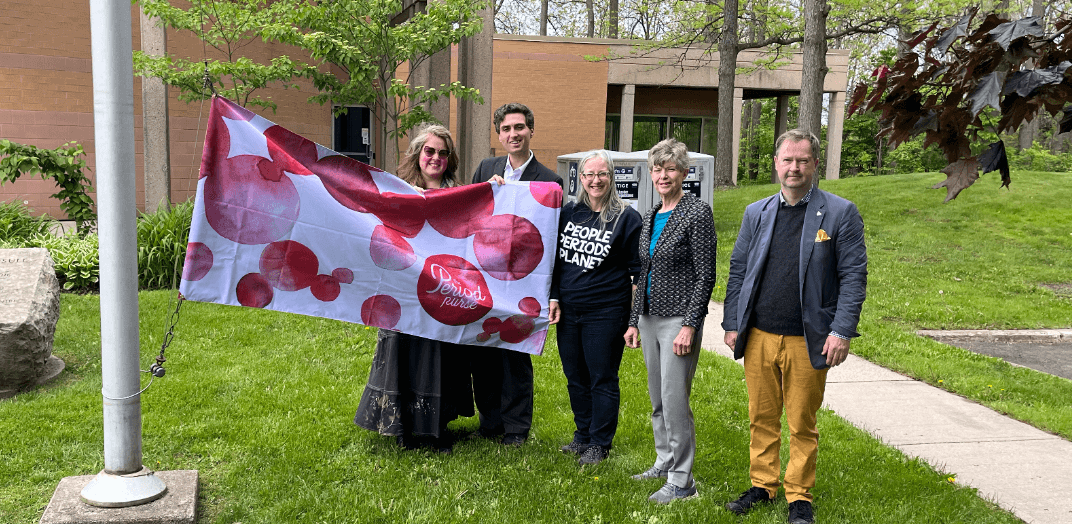 Staff and volunteers holding up a banner