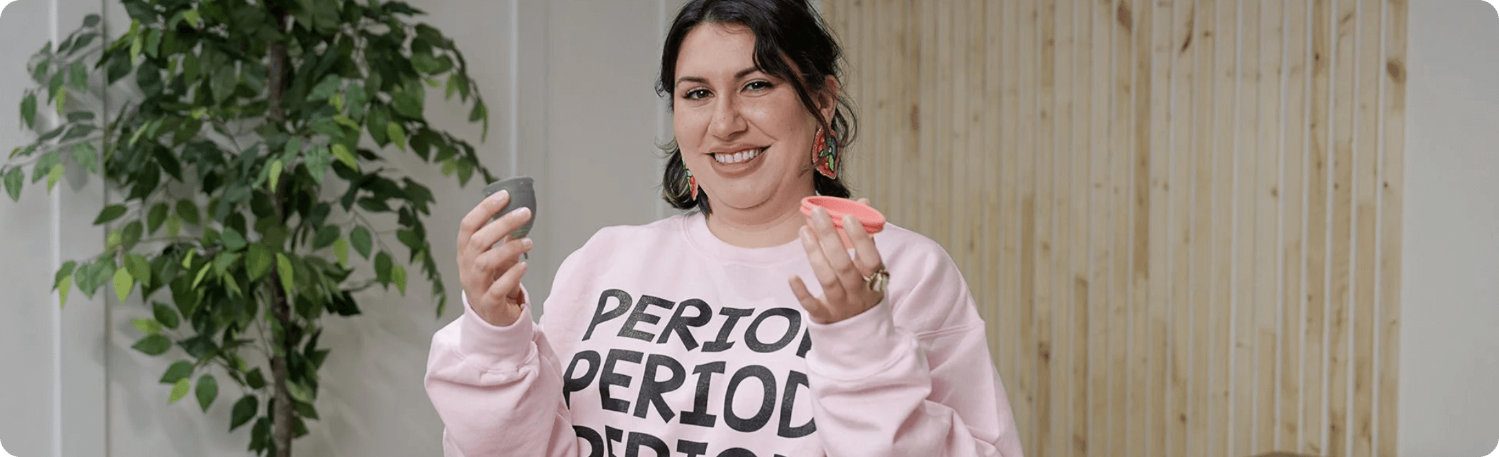 A picture of a woman smiling, wearing a shirt that says Period