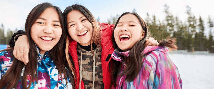 Three smiling women outside