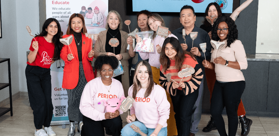 Volunteers posing and smiling in front of a camera