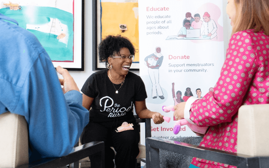 A staff laughing with other participants in a workshop