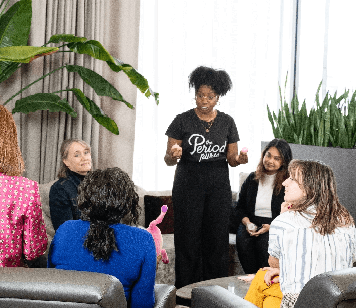 A woman giving a presentation to a circle of adults