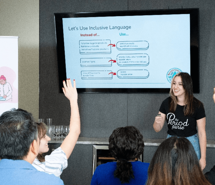 A woman giving a presentation in front of a workplace