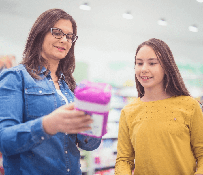 A teacher showing a hygiene product to a female student