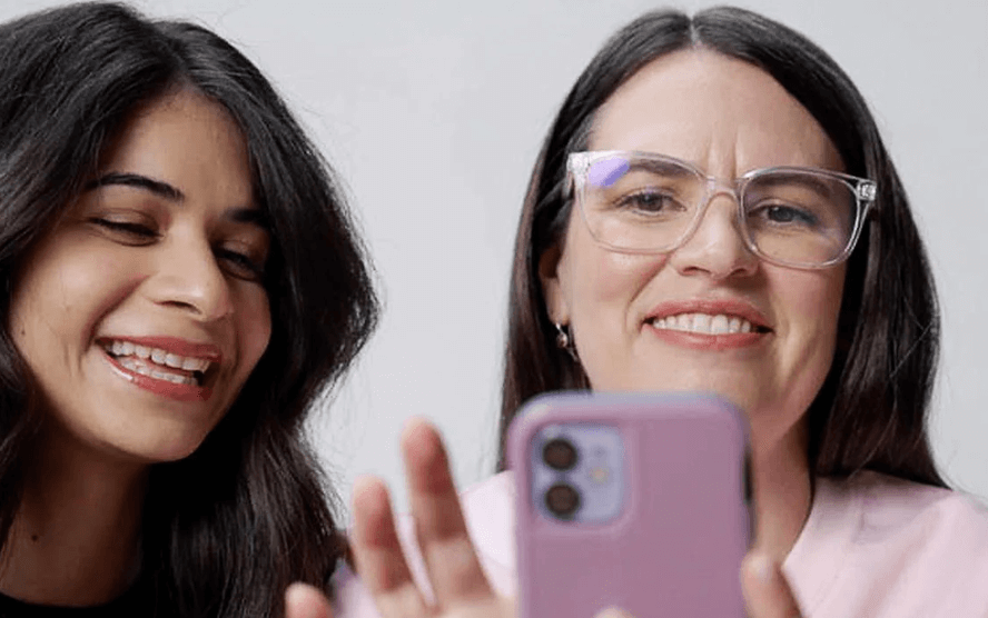 Two women looking at a cellphone screen