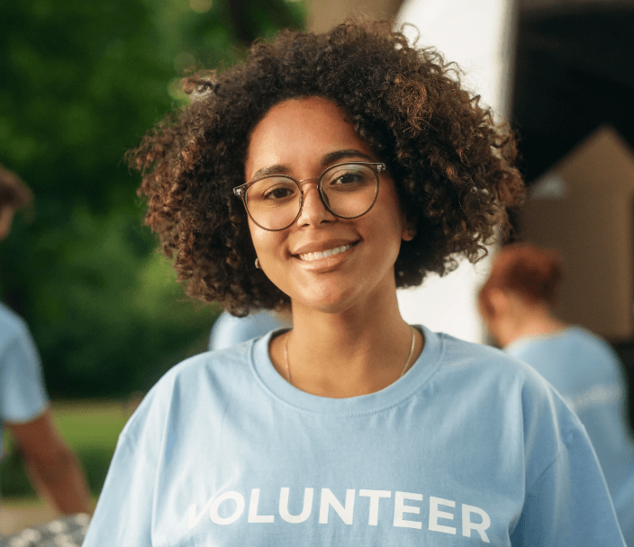 A smiling woman wearing a shirt that says Volunteer