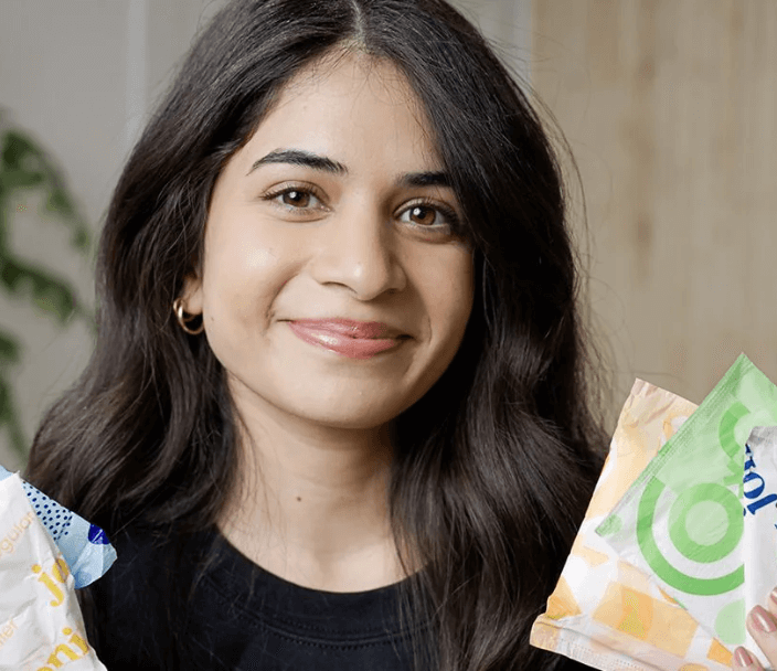 A smiling woman holding sanitary products