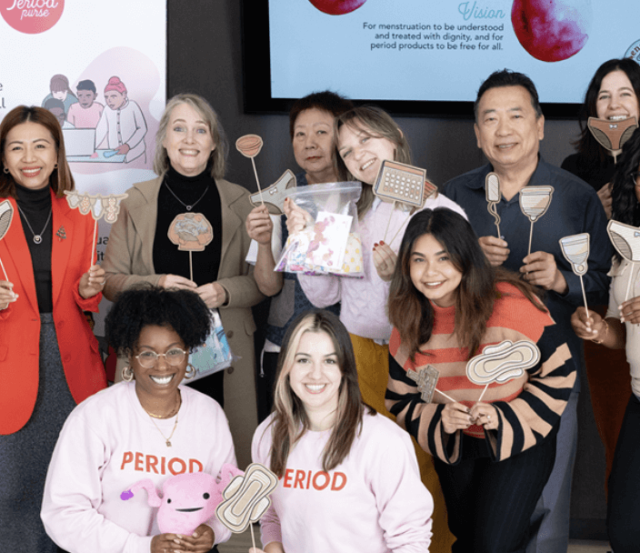 Volunteers posing and smiling in front of a camera